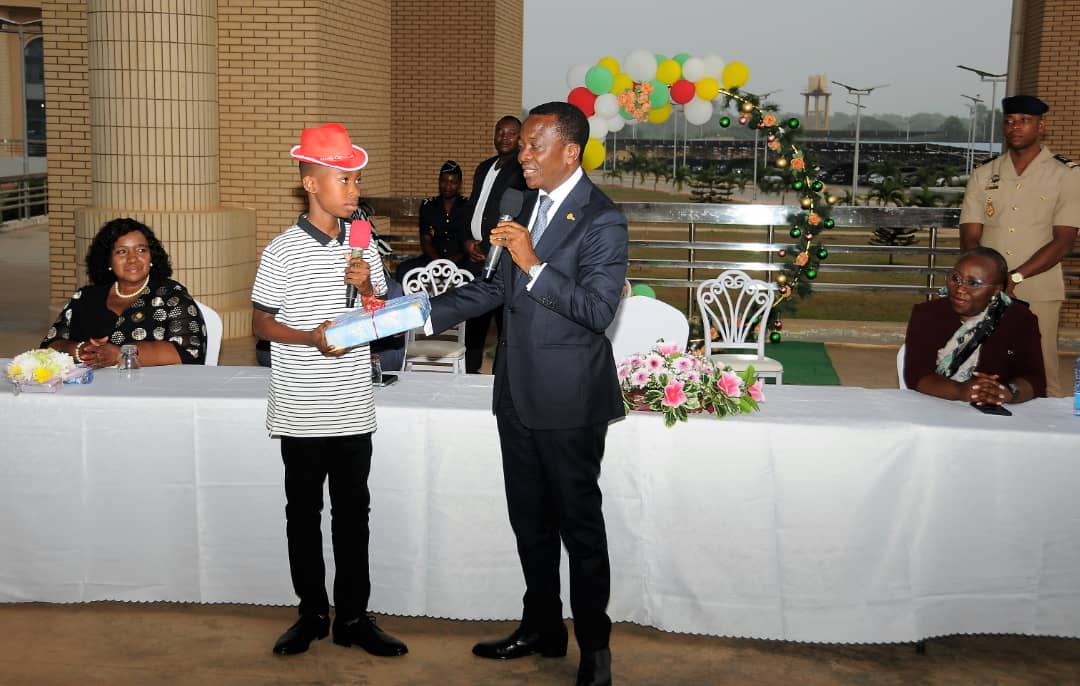 Adedze kodjo remettant symbolique un cadeau a un enfant