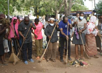 Le maire Konou en lunette en train de balayer min