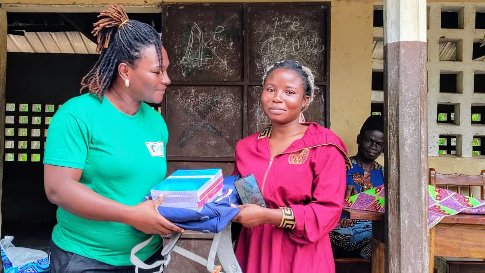 Des kits scolaires et vestimentaires aux orphelins, veuves et veufs de Kaniamboua 1 9 Mme Akouh remettant son kit a une beneficiaire