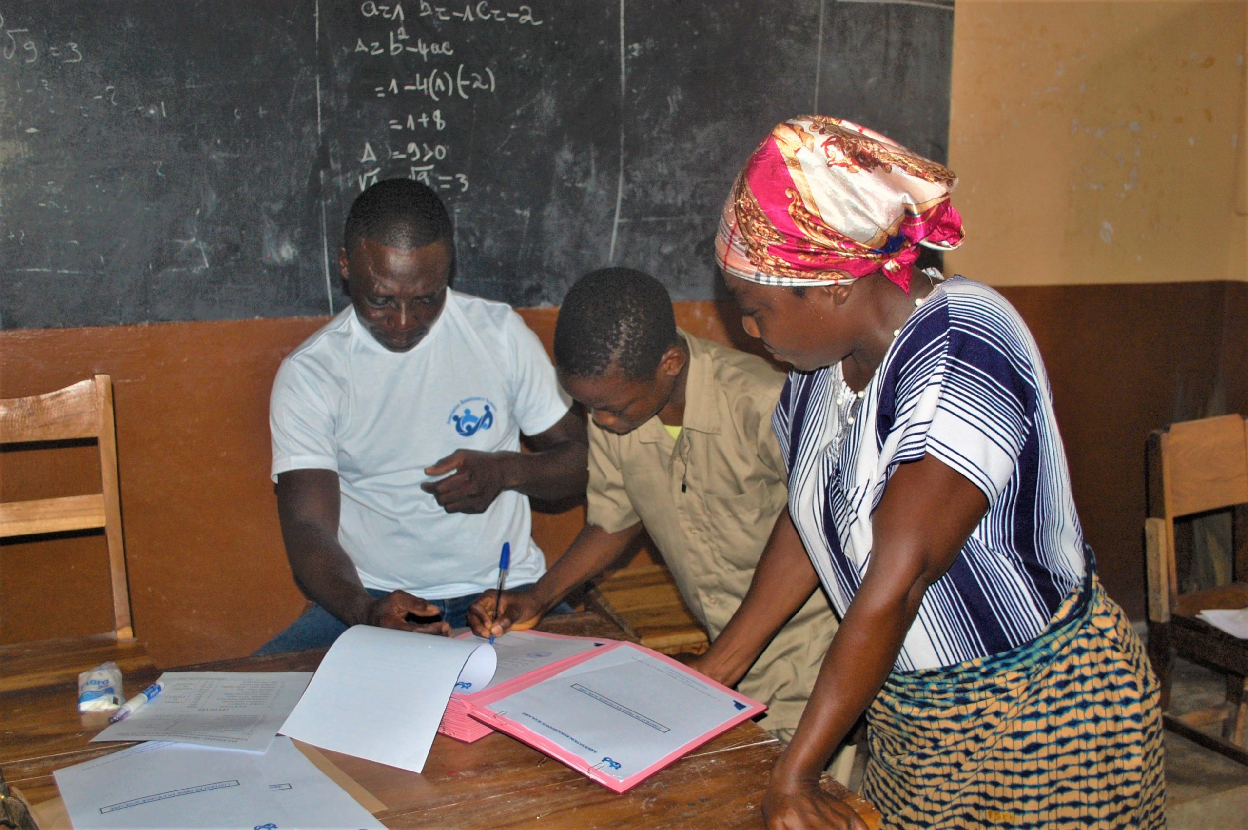 Un eleve avec sa maman signe son contrat grace a la renaissance scolaire scaled