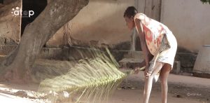 Adjovi met au propre la devanture avec le balai tissé