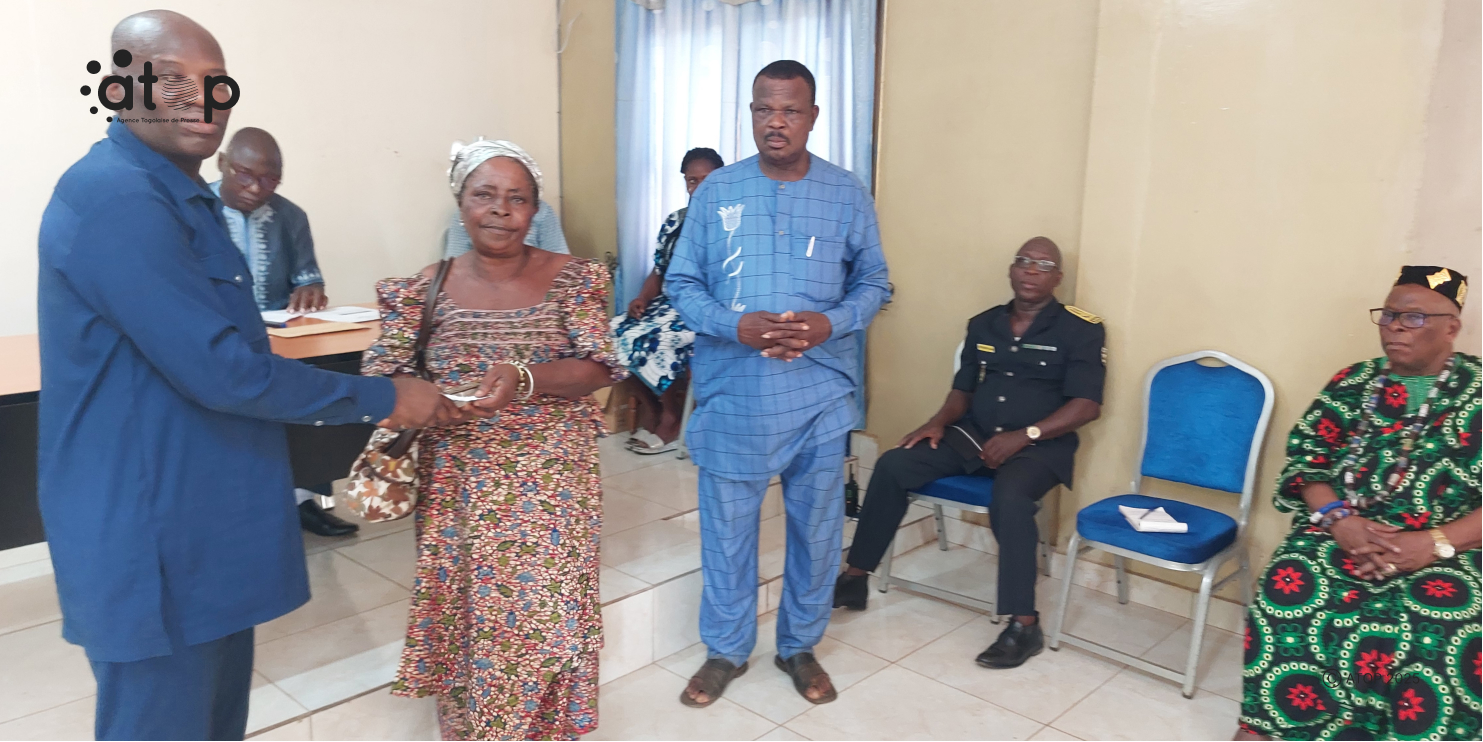9 Le prefet de Yoto a gauche remettant largent a une beneficiaire