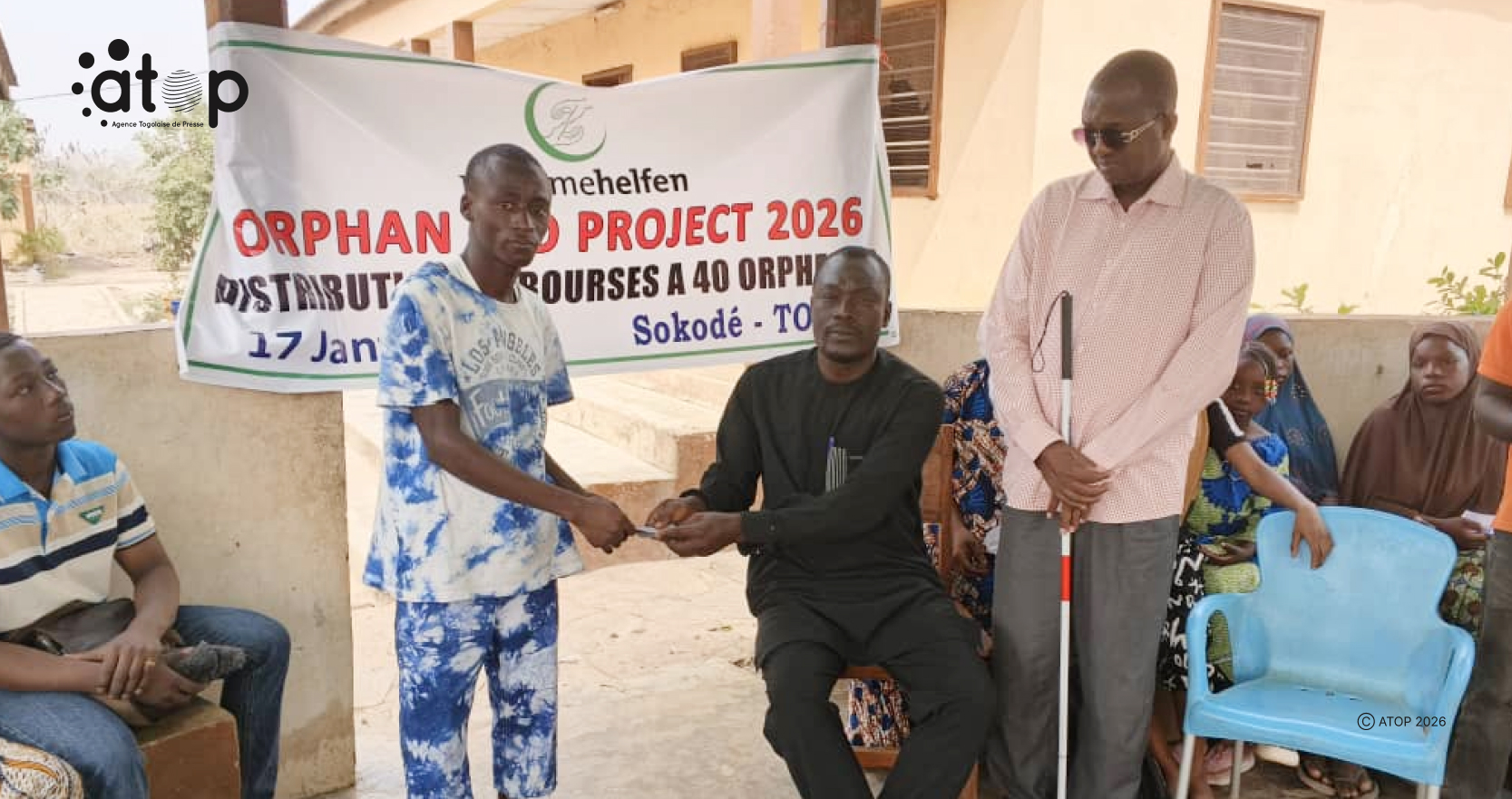 16 Un beneficiaire recevant sa bource en presence du Dr El Hadj Asmanou debout