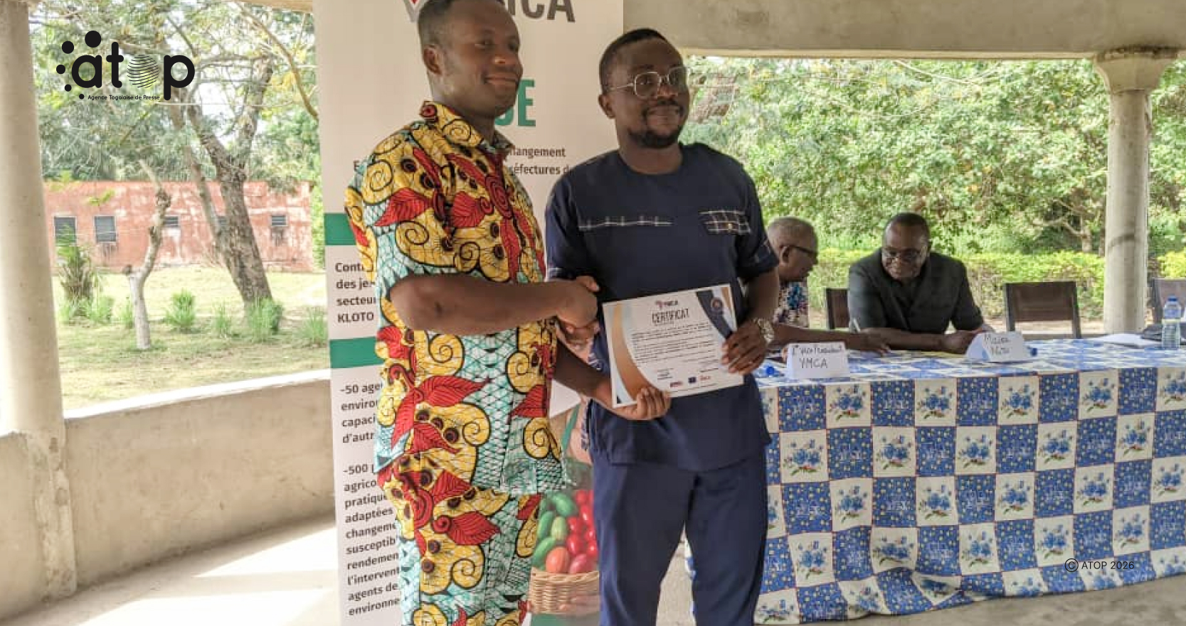 7 M. Noviva en complet pagne recevant son certificat