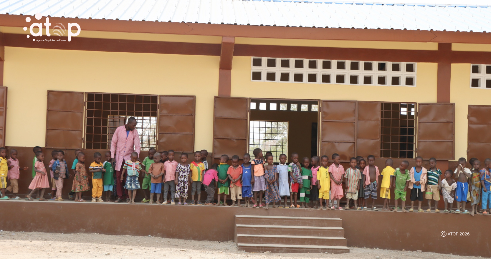 Le directeur et apprenants devant linfrastructure