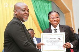 Le ministre remettant son diplome a une recipiendaire