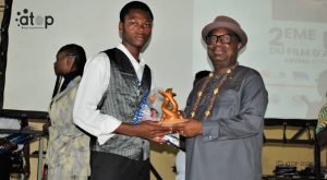 11 Un recipiendaire recoit son prix des mains de president du KIFFMU