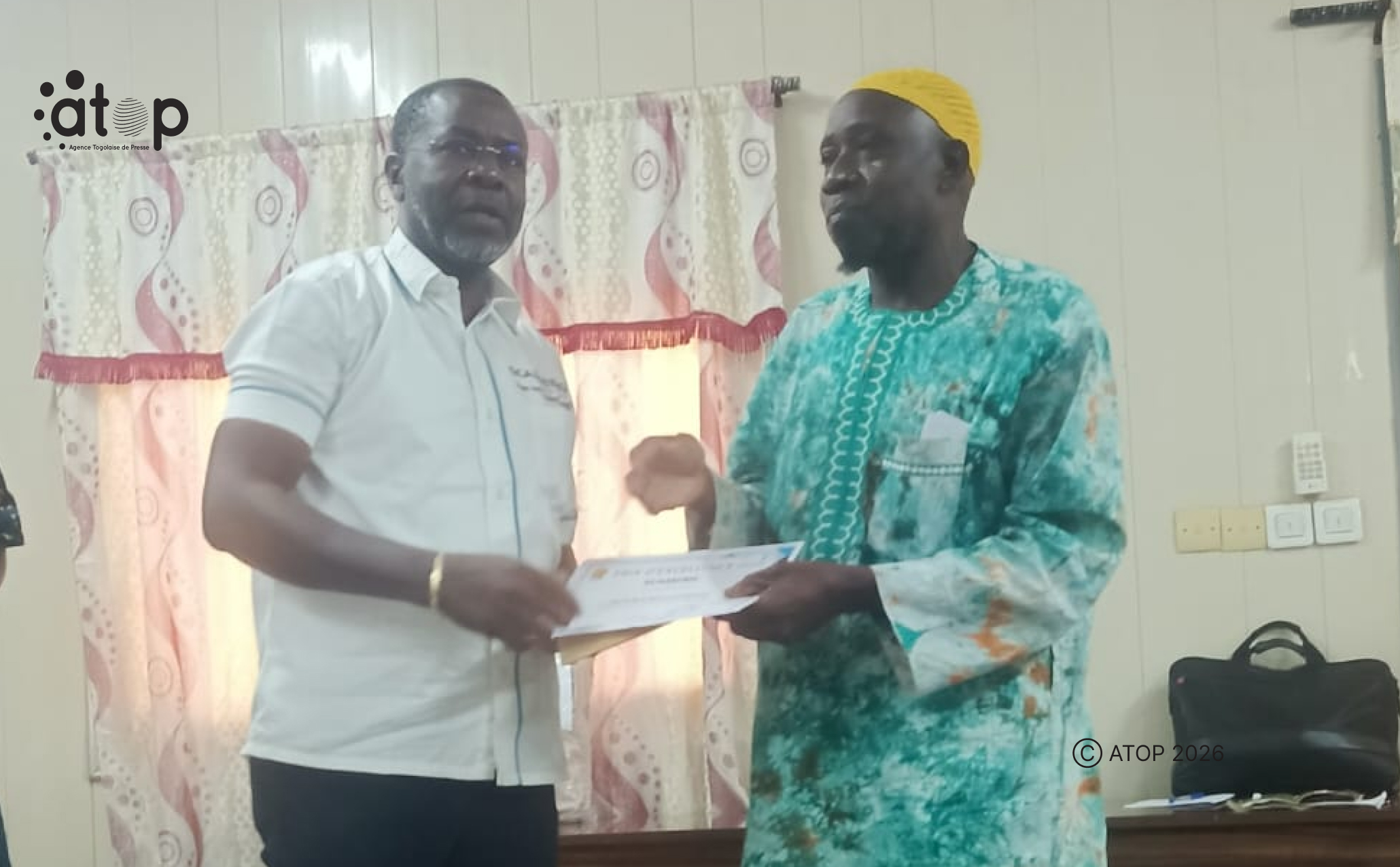10 Le representant resident de Scanning a Ouagadougou a gauche remet le prix au parent dun laureat absent