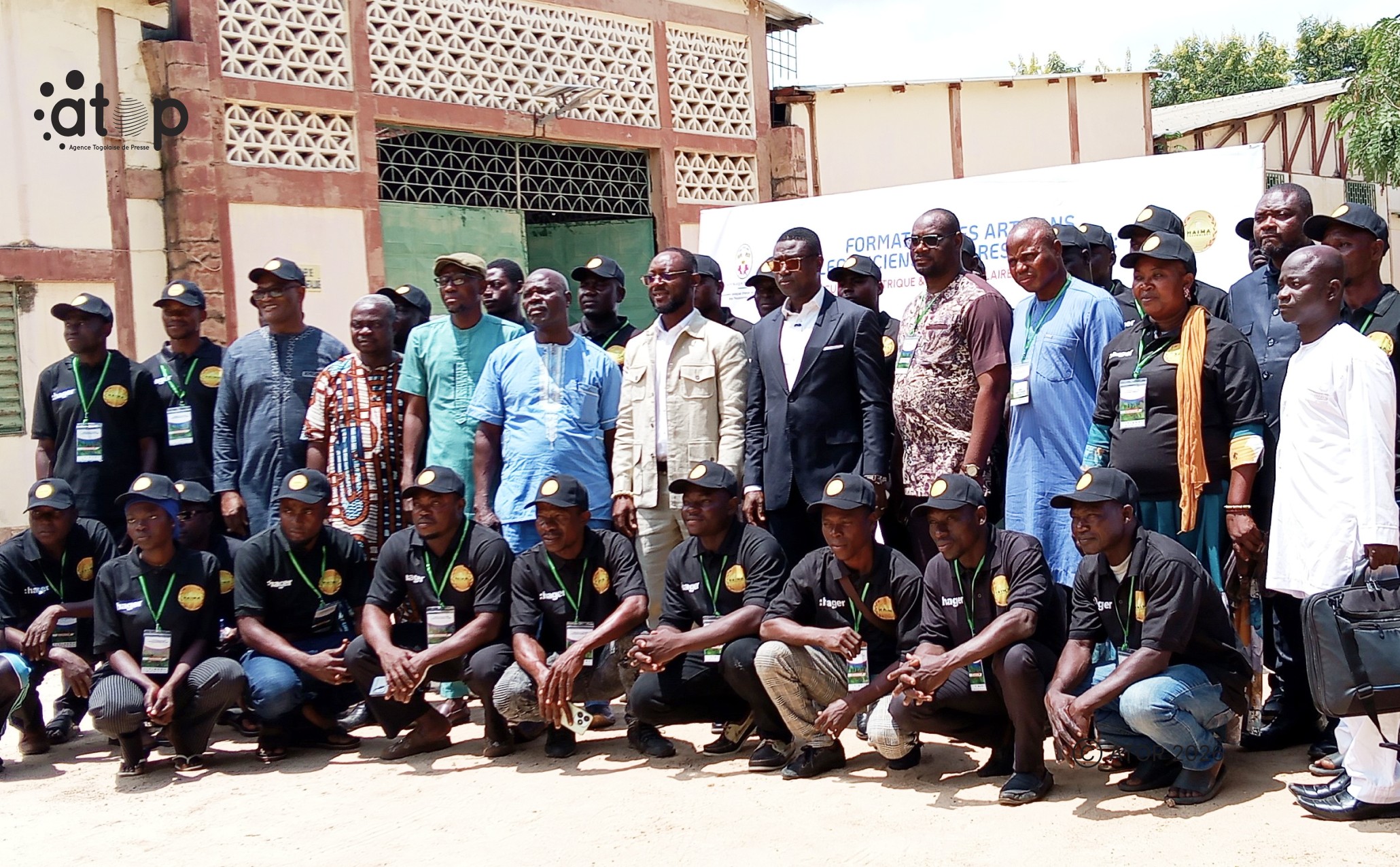 15 Electriciens en T Shirt et casquette noire ont pose avec les officiels
