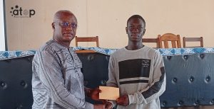 2 Le senateur Djato Tassounti remettant une enveloppe financiere a un eleve