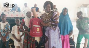 73 Mme Kadessole remet des fournitures scolaire a une eleve